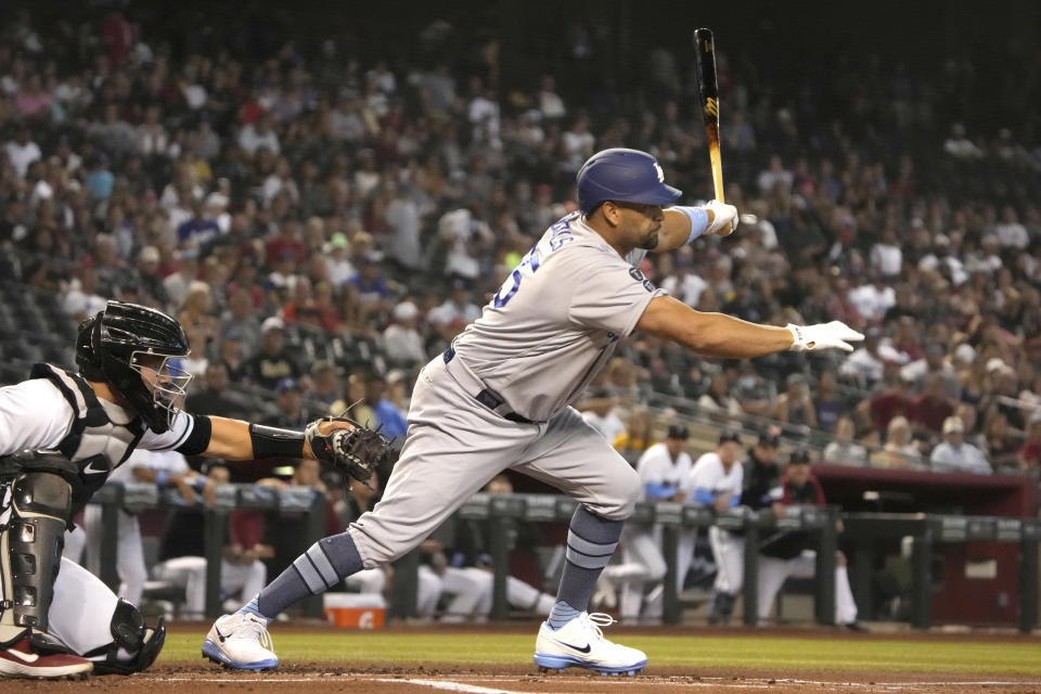 Los Angeles Dodgers' Albert Pujols hits a single against the Arizona Diamondbacks in the first inning during a baseball game, Sunday, June 20, 2021, in Phoenix. (AP Photo/Rick Scuteri)