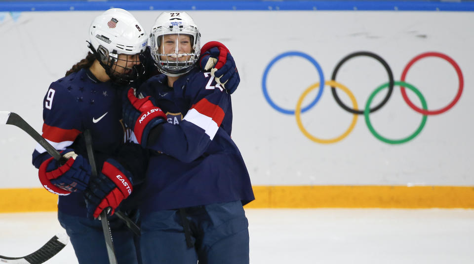 Megan Bozek of the United States, left, congratulates Kacey Bellamy of the United States after Bellamy scored a goal against Sweden during the first period of the 2014 Winter Olympics women's semifinal ice hockey game at Shayba Arena Monday, Feb. 17, 2014, in Sochi, Russia. (AP Photo/Julio Cortez)