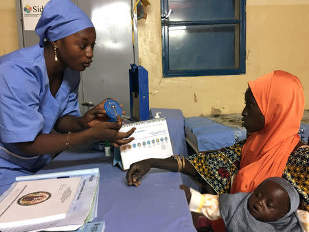 A Marie Stopes nurse explains to mother-of-three Kadidja Toudjani how a contraceptive implant works in Niger's village of Libore, about 20km southeast of the capital Niamey, Niger November 2, 2017. REUTERS/Tim Cocks
