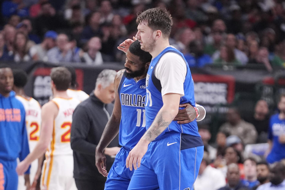 Dallas Mavericks guard Luka Doncic hugs guard Kyrie Irving (11) during the first half of the team's NBA basketball game against the Atlanta Hawks in Dallas, Thursday, April 4, 2024. (AP Photo/LM Otero)