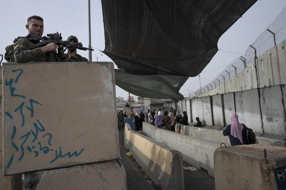 FILE - Israeli Border Police officers secure a checkpoint used by Palestinian to cross from the West Bank into Jerusalem, for the first Friday prayers in the Muslim holy month of Ramadan at the Al Aqsa mosque compound, at the Qalandia Israeli army checkpoint, west of Ramallah, April 8, 2022. Days of violence in Jerusalem and an exchange of fire in Gaza overnight have raised the possibility that Israel and Gaza's Hamas rulers will once again go to war, as they did less than a year ago under similar circumstances. For Israel, war could set back efforts to sideline the conflict and damage ties with Arab states. (AP Photo/Nasser Nasser, File)