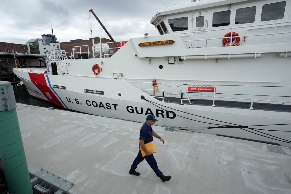 The U.S. Coast Guard Cutter Warren Deyampert is docked as a member of the Coast Guard walks past in June at Coast Guard Base Boston.