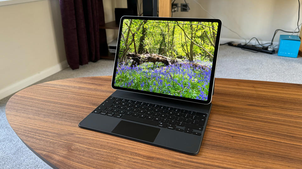 Tablet: Apple iPad Pro 12.9 6th Generation on a desk with a forest on screen