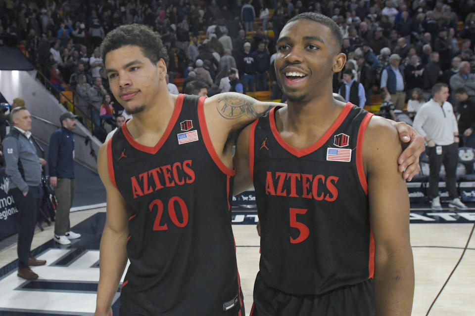 San Diego State guards Matt Bradley (20) and Lamont Butler (5) walk off the court after the team's win over Utah State in an NCAA college basketball game Wednesday, Feb. 8, 2023, in Logan, Utah. (AP Photo/Eli Lucero)