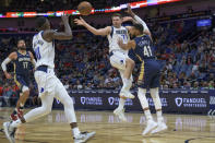Dallas Mavericks guard Luka Doncic (77) passes against New Orleans Pelicans forward Garrett Temple (41) in the first half of an NBA basketball game in New Orleans, Wednesday, Dec. 1, 2021. (AP Photo/Matthew Hinton)