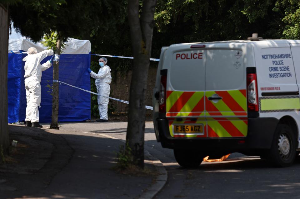 Police forensics officers work inside a cordon on Magdala Road in Nottingham, central England, following a 'major incident' in which three people were found dead. Police arrested a man Tuesday after three people were found dead and a van tried to mow down three others in the central English city of Nottingham in incidents authorities believe are linked. Nottingham's centre was cordoned off, with a heavy police presence, including some armed officers following the events that left residents shaken. (Photo by Darren Staples / AFP) (Photo by DARREN STAPLES/AFP via Getty Images)