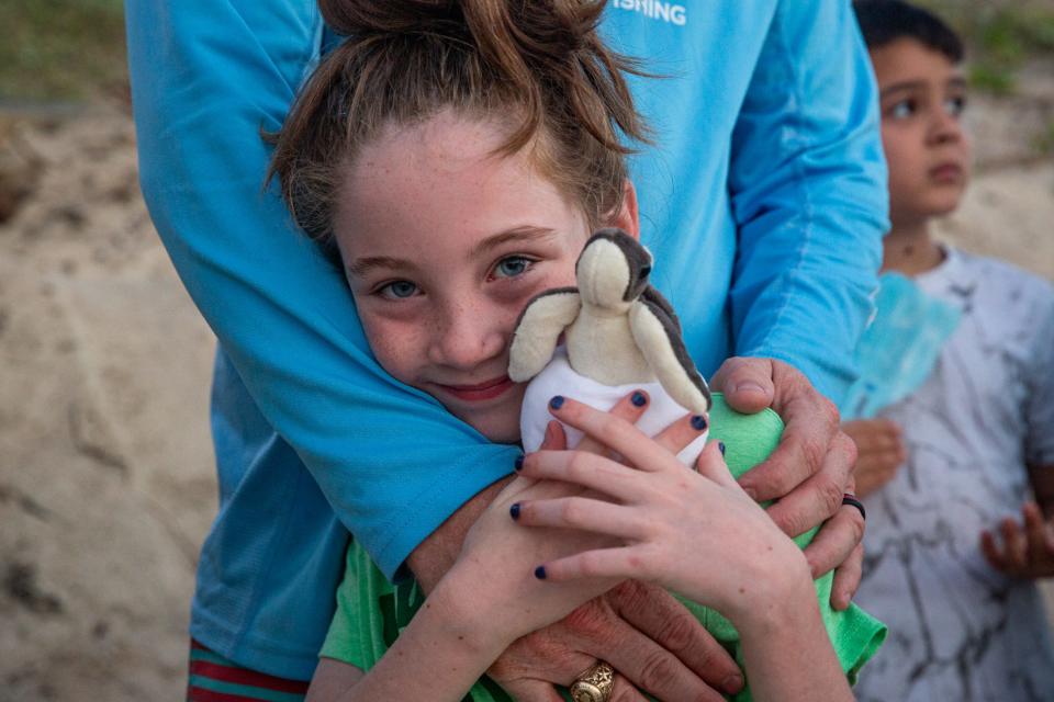 Bella Neese, 8, of Boerne, holds a stuffed sea turtle hatchling during a public release of Kemp's ridley sea turtles at Padre Island National Seashore on June 28, 2024, in Corpus Christi, Texas.