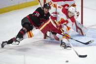 Calgary Flames defenceman Juuso Valimaki battles with Ottawa Senators left wing Tim Stutzle in front of the net during the second period of an NHL hockey game Thursday, Feb. 25, 2021, in Ottawa, Ontario. (Adrian Wyld/The Canadian Press via AP)