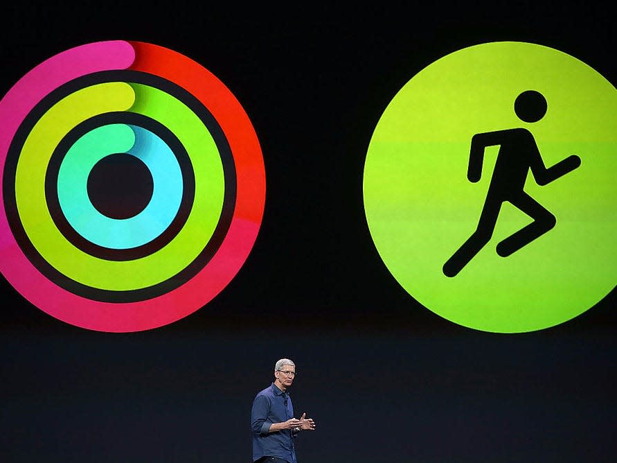 Tim Cook in front of a large screen showing graphics for Apple's fitness apps.
