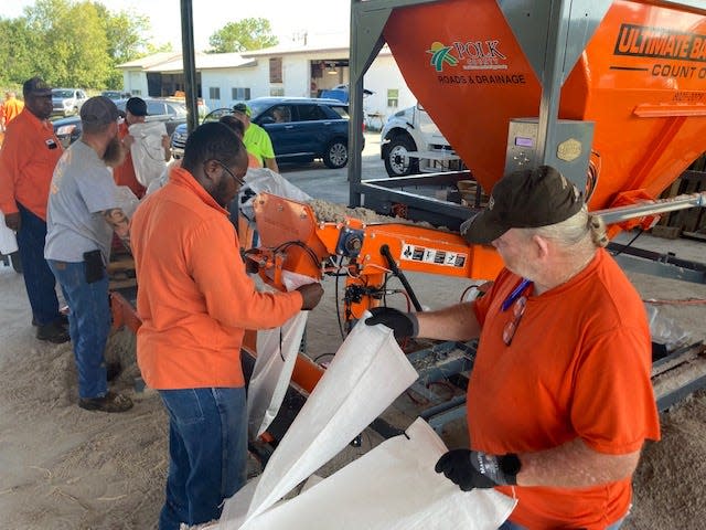 County workers and residents load bags full of sand at the Mulberry distribution site Monday morning ahead of Hurricane Ian.