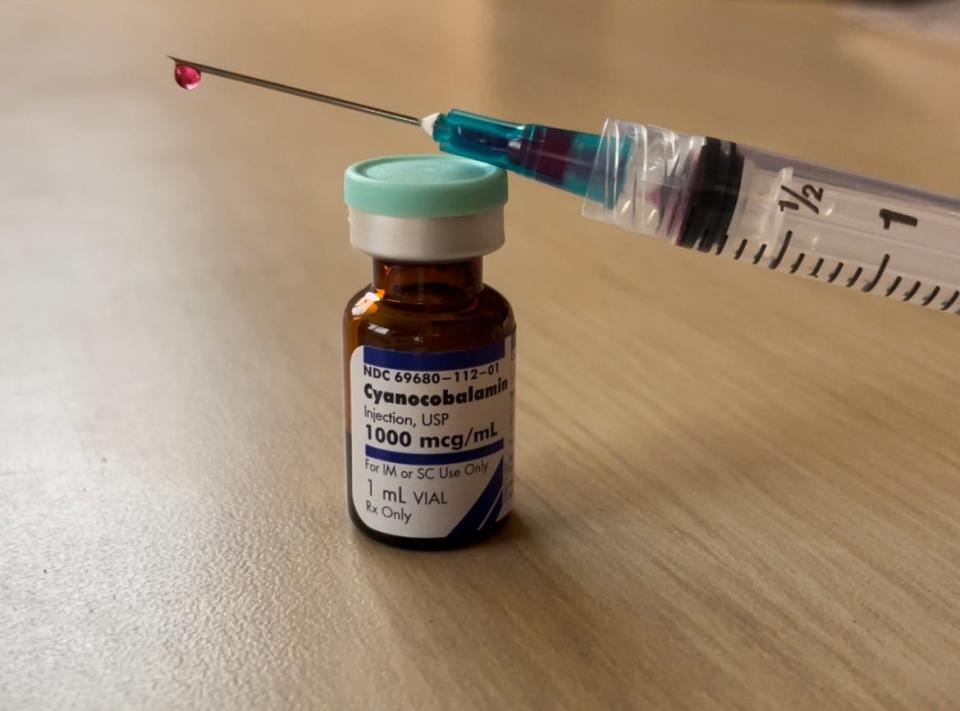 A syringe dripping vitamin B12 rests on a vial containing one intramuscular dose of cyanocobalamin (cobalamin/B12). Micki Wise, 92, takes one shot every month for pernicious anemia; however, depending on the patient’s medical history, they may need more frequent doses, according to Penn Medicine.