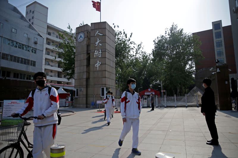 FILE PHOTO: Students wearing face masks leave a school in Beijing