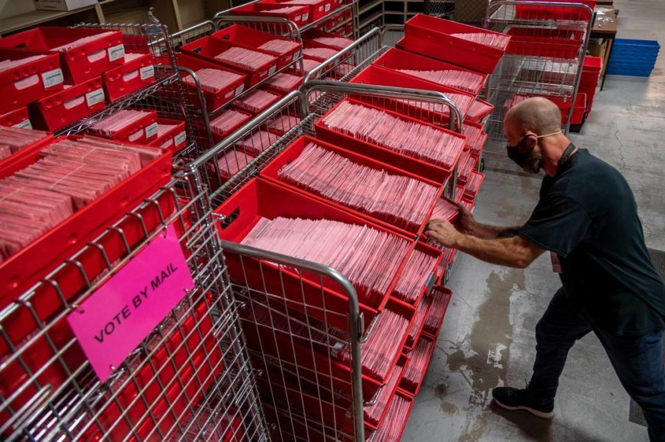 Election assistant David Quiel sorts vote-by-mail ballots at the Sacramento County Voter Registration and Elections Office in November 2020.