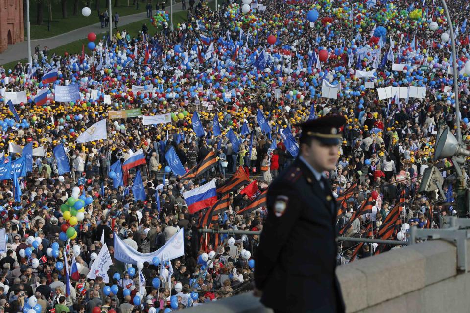 People walk with flags and banners towards St. Basil's Cathedral on Red Square during a rally in Moscow May 1, 2014. Russians celebrate the coming of Spring and since communist times, Labour Day on the first day of May. (REUTERS/Maxim Shemetov)