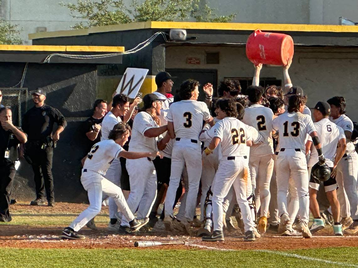 Miami Sunset players surround center fielder Pupi Gonzalez at home plate after his two-run walk-off home run on Friday afternoon to beat St. Brendan 7-5 in a Region 4-4A semifinal at Raul Ibanez Field.