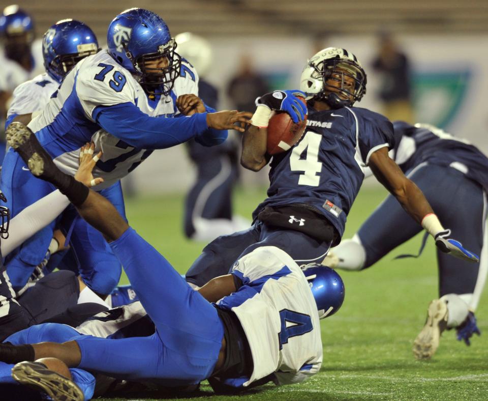 Trinity Christian defenders Marc Everhart (79) and Nick Washington combine to tackle American Heritage running back Greg Bryant (4) during the 2010 Class 1A football championship.