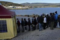 Migrants wait in a queue before the visit of Pope Francis at the Karatepe refugee camp, on the northeastern Aegean island of Lesbos, Greece, Sunday, Dec. 5, 2021. Pope Francis is returning to Lesbos, the Greek island that was at the heart of a massive wave of migration into Europe six years ago, after making pointed criticism of European governments on the handling of the crisis during a visit to two hard-hit countries. (AP Photo/Alessandra Tarantino)