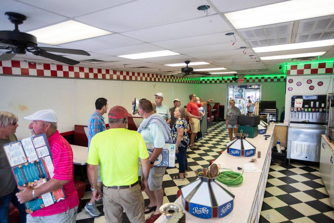 Patrons buy fixtures, menus and merchandise from Parkette Drive-In during a sale in Lexington, Ky., Saturday, July 23, 2022.