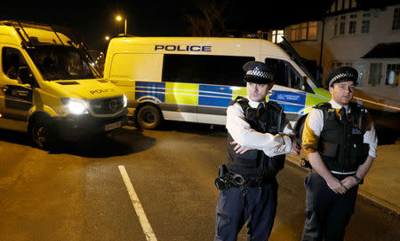 Police vehicles and officers guard the home of Nikolai Glushkov while his corpse is removed, in New Malden, Britain March 13, 2018. REUTERS/Peter Nicholls