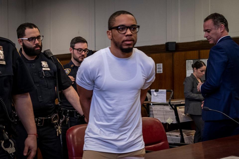 Tyrese Haspil in a courtroom, with his hands cuffed behind his back.