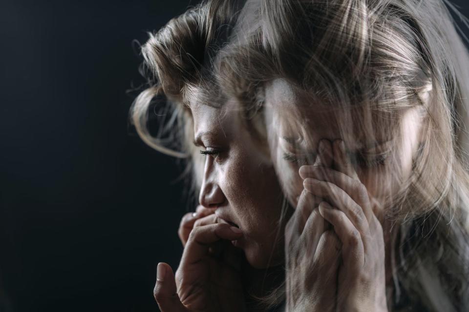 A double exposure of a woman with her hands in front of her mouth.