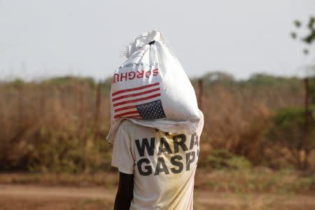 A man carries a bag of food aid at the Kakuma refugee camp in northern Kenya, March 6, 2018. REUTERS/Baz Ratner