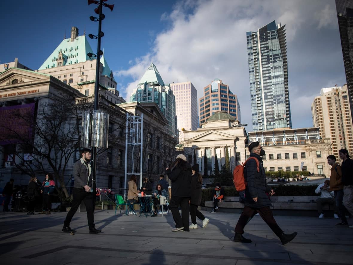 People walk through Robson Square near the Vancouver Art Gallery in Vancouver in March 2022. The City of Vancouver has been a certified living wage employer for more than five years, meaning it's committed to paying its employees and contractors a 'living wage'. (Ben Nelms/CBC - image credit)