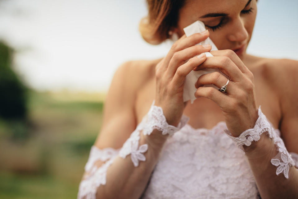 Beautiful bride in white dress weeps tears