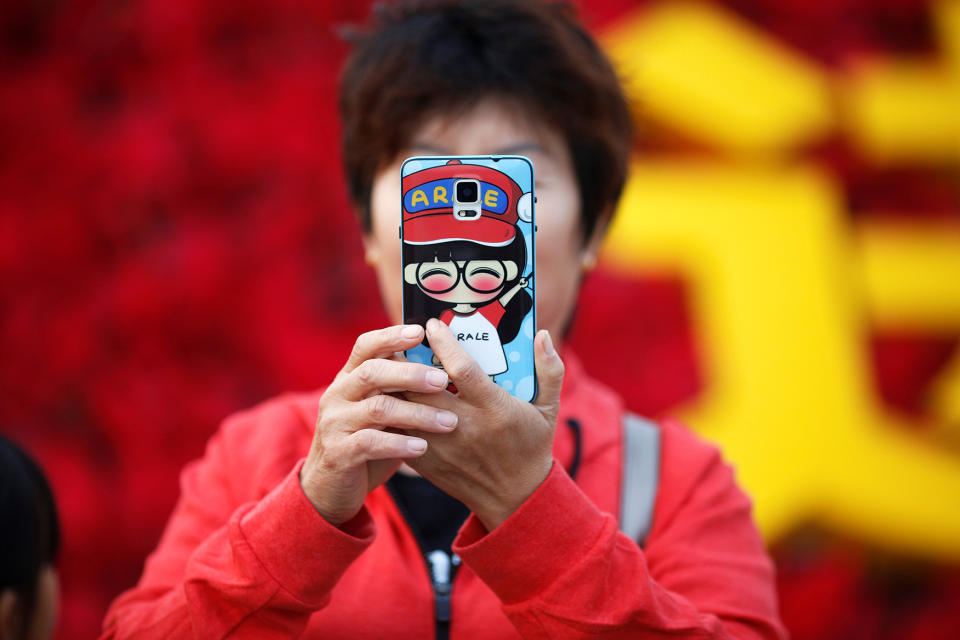 <p>A woman takes pictures of herself as people gather in Tiananmen Square to celebrate National Day marking the 67th anniversary of the founding of the People’s Republic of China, in Beijing October 1, 2016. (REUTERS/Damir Sagolj) </p>