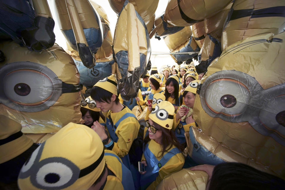 ARCHIVO - Participantes vestidos como los Minions de la franquicia "Despicable Me" caminan entre globos de Minions durante la Minions Run en Tokio el 13 de febrero de 2016. (Foto AP/Eugene Hoshiko, archivo)