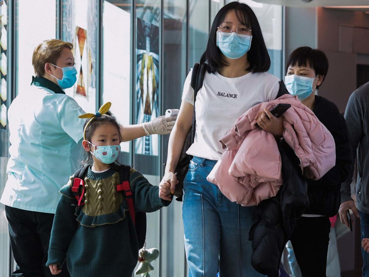 A health officer screens arriving passengers from China at Changi International airport in Singapore: AFP via Getty Images