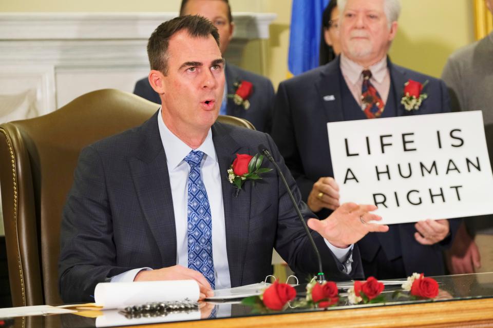 Gov. Kevin Stitt's signs Senate Bill 612 on April 12  in the Blue Room at the Capitol.