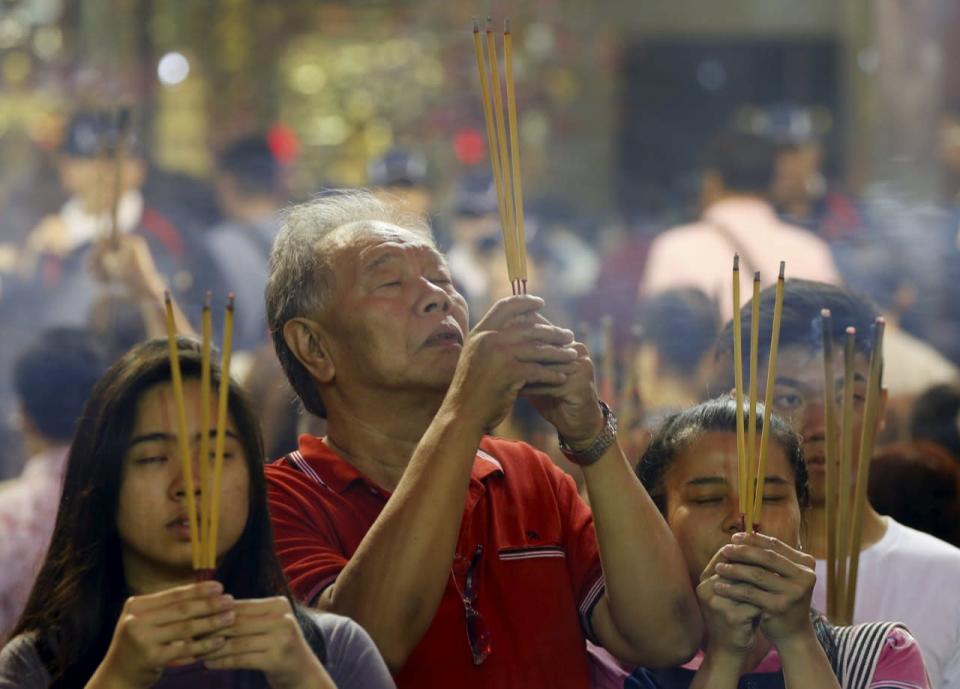 People pray with joss sticks ahead of the Lunar New Year at Kwan Im Thong Hood Cho temple on 7 February. Photo: Reuters/Edgar Su.