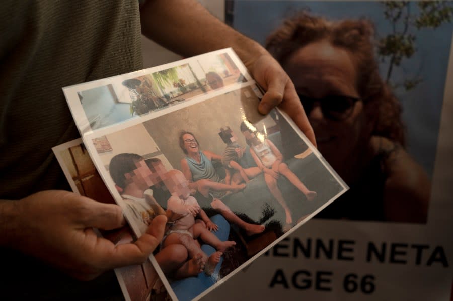 Nahal Neta, son of Adrienne Neta, 66, holds a photo of the nurse living in Kibbitz Be’eri missing since a Hamas surprise attack on the Gaza border, after a news conference by U.S. citizens whose relatives are missing, in Tel Aviv, Israel, Tuesday, Oct. 10, 2023. (AP Photo/Maya Alleruzzo)