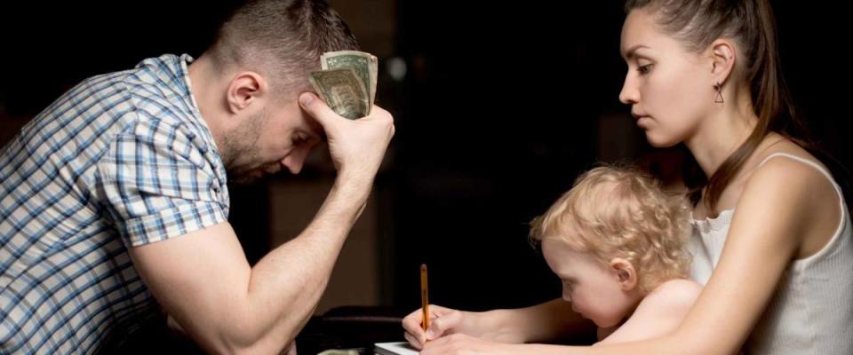 A family with a small child considers struggles with bills late in the evening.