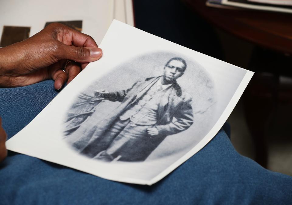 Gladys Johnson Dorsey, 73, holds a photo of her great, great, great grandfather Oliver Lewis at the home of her sister, Ruth Johnson-Watts, 81, in Cincinnati on March 20, 2024. They are descendants of Lewis, who was the first jockey to win the Kentucky Derby in 1875.