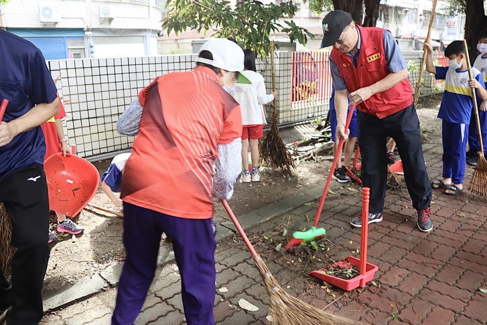 謝文斌(右二)拿起掃帚掃地。   圖：高雄市教育局提供