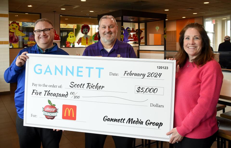 Blissfield High School teacher Scott Ricker, center, is presented with a ceremonial $5,000 check from Michael Bodman, left, owner of the McDonald's restaurants in Adrian, and Kimberly Zimmerman of LocaliQ/Gannett Media Group on Wednesday at the South Main Street McDonald's. Ricker was named an Amazing Teacher by Gannett.