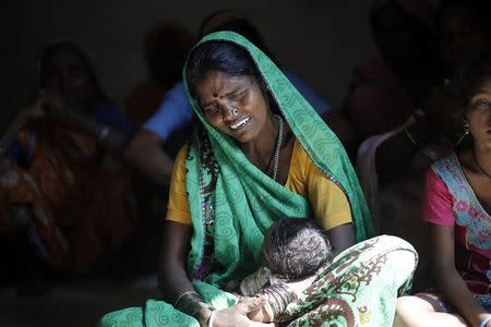 Indra Bai, the mother of a deceased victim who died after she underwent a sterilization surgery at a government mass sterilisation camp, holds a child as she mourns in her house at Bilaspur district in the eastern Indian state of Chhattisgarh November 14, 2014. REUTERS/Anindito Mukherjee