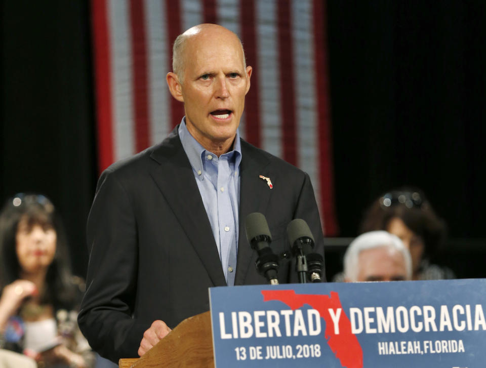 FILE- In this July 13, 2018 file photo, Florida Gov. Rick Scott, speaks to Cuban-American supporters at a campaign stop, in Hialeah, Fla. Incumbent Democratic Sen. Bill Nelson and Republican challenger Scott are meeting in the first debate in their campaign for Florida's highly competitive U.S. Senate seat. The two will square off Tuesday, Oct. 2, 2018, for the taped event in the studios of Telemundo 51 in Miramar. (AP Photo/Wilfredo Lee, File)