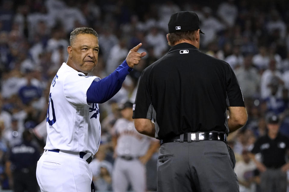 Los Angeles Dodgers manager Dave Roberts, left, argues with first base umpire Ed Hickox after San Francisco Giants' Darin Ruf walked with the bases loaded during the ninth inning of a baseball game Thursday, July 22, 2021, in Los Angeles. (AP Photo/Marcio Jose Sanchez)