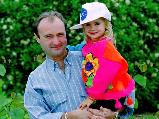 <p>Dave Hogan/Hulton Archive/Getty</p> Phil Collins holding his daughter Lily Collins as a child