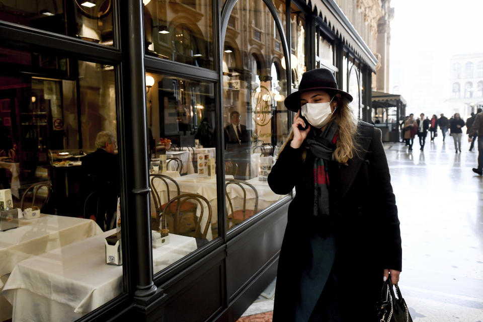 A woman wearing a sanitary mask talks on the phone as she walks in the Vittorio Emanuele Gallery shopping arcade, in downtown Milan, Italy, Monday, Feb. 24, 2020. At least 190 people in Italy’s north have tested positive for the COVID-19 virus and four people have died, including an 84-year-old man who died overnight in Bergamo, the Lombardy regional government reported. (Claudio Furlan/Lapresse via AP)