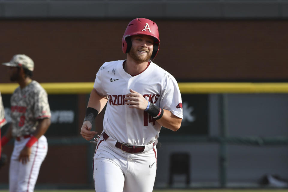 Arkansas batter Cullen Smith (14) rounds the basses after hitting a grand slam against North Carolina State in the second inning of an NCAA college baseball super regional game Friday, June 11, 2021, in Fayetteville, Ark. (AP Photo/Michael Woods)