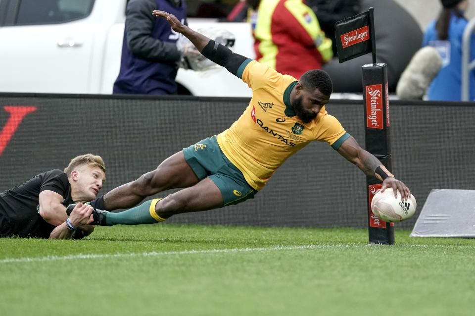 Australia's Marika Koroibete, right, scores a try in the tackle of New Zealand's Damian McKenzie during the Bledisloe Cup rugby game between the All Blacks and the Wallabies in Wellington, New Zealand, Sunday, Oct.11, 2020. (John Cowpland /Photosport via AP)