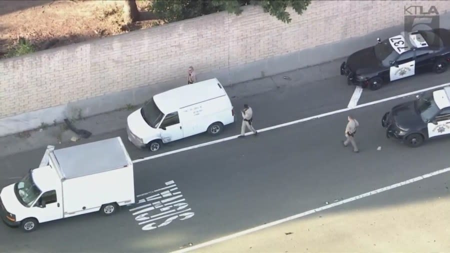 Officers surround the suspect again after he took off and pulled over at the Long Beach Boulevard exit. (KTLA)