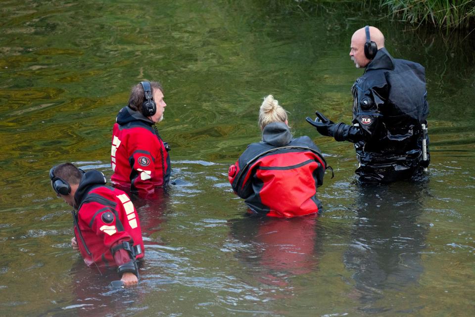 Water Recovery authorities comb the Apple River with metal detectors after five people were stabbed while tubing down the river Saturday, July 30, 2022, in Somerset, Wisconsin.