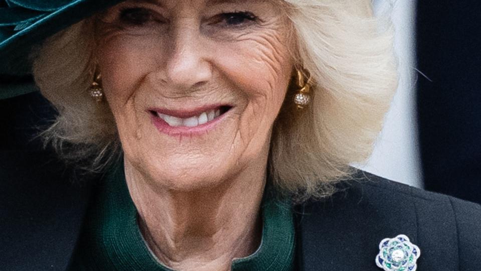 Camilla smiling wearing Queen Mary's brooch
