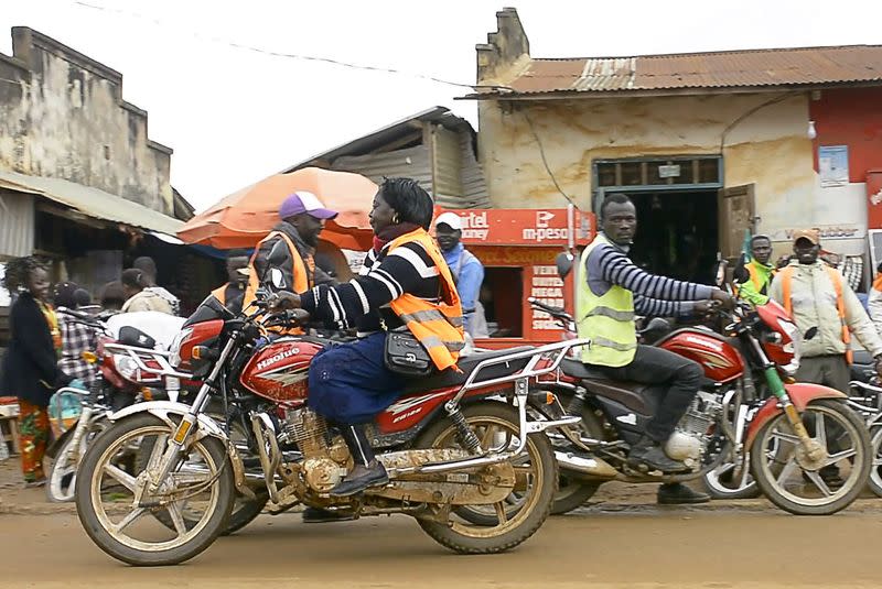 Congolese motorbike taxi rider Imelda Mmambu rides her motorbike as she waits for potential clients along the streets of Beni