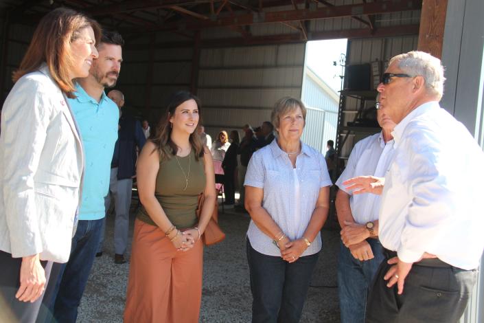 United States Secretary of Agriculture Tom Vilsack, right, talks with the Spellman family and Democratic U.S. Rep. Cindy Axne on Thursday, Aug. 18, 2022, during a visit to the Spellman farm in Woodward.